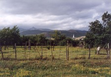 A magyarigeni református templom, háttérben a Kecske-kővel